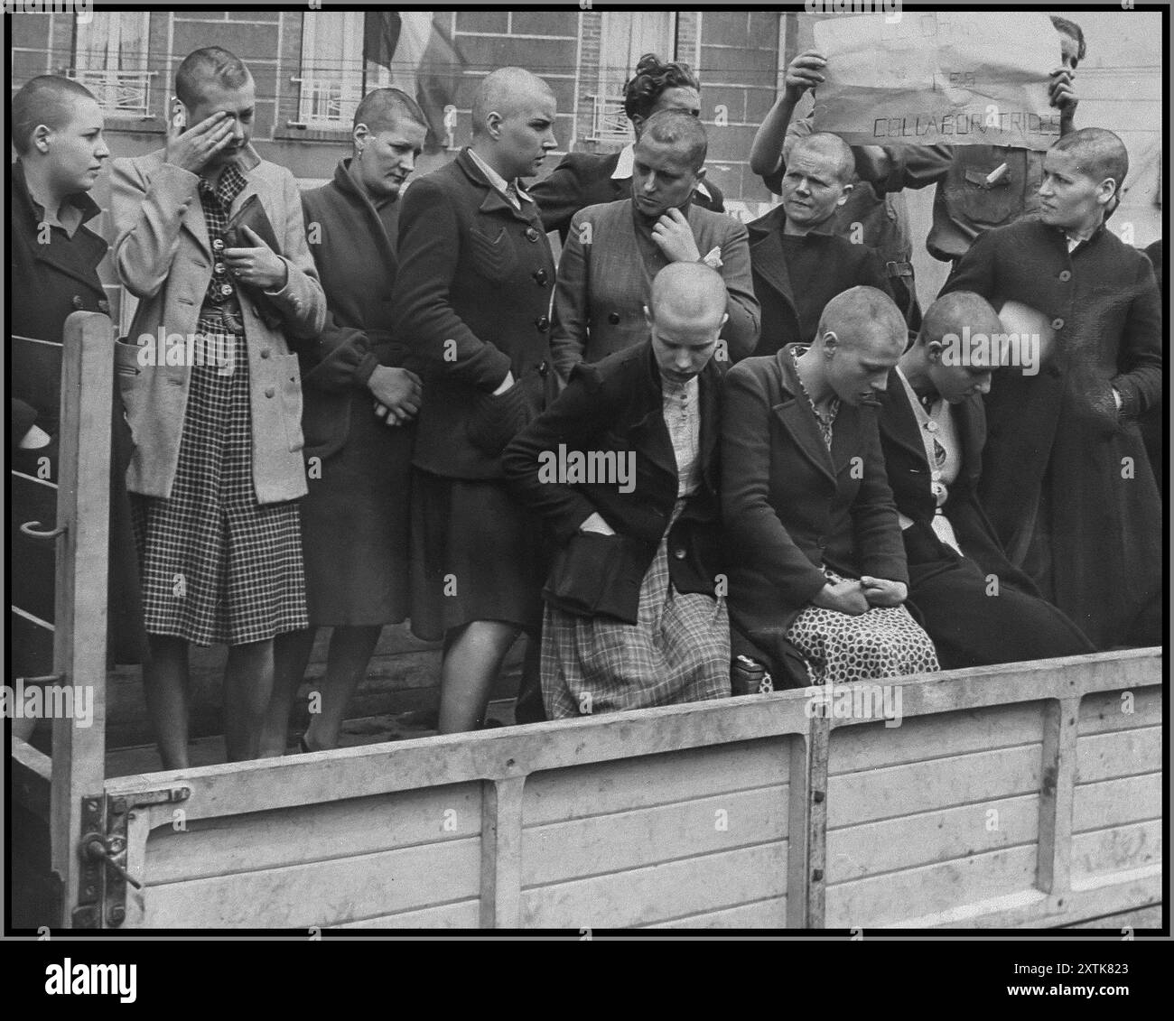 FRANZÖSISCHE KOLLABORATEURE WW2 Frauen, die sich während der Besatzung mit den Deutschen verbündeten, werden von Mitgliedern des französischen Widerstands durch die Straßen Cherburgs getrieben. Ihr Kopf wurde rasiert, um sie zu demütigen. 14. Juli 1944. Cherbourg, [Manche] Frankreich Stockfoto