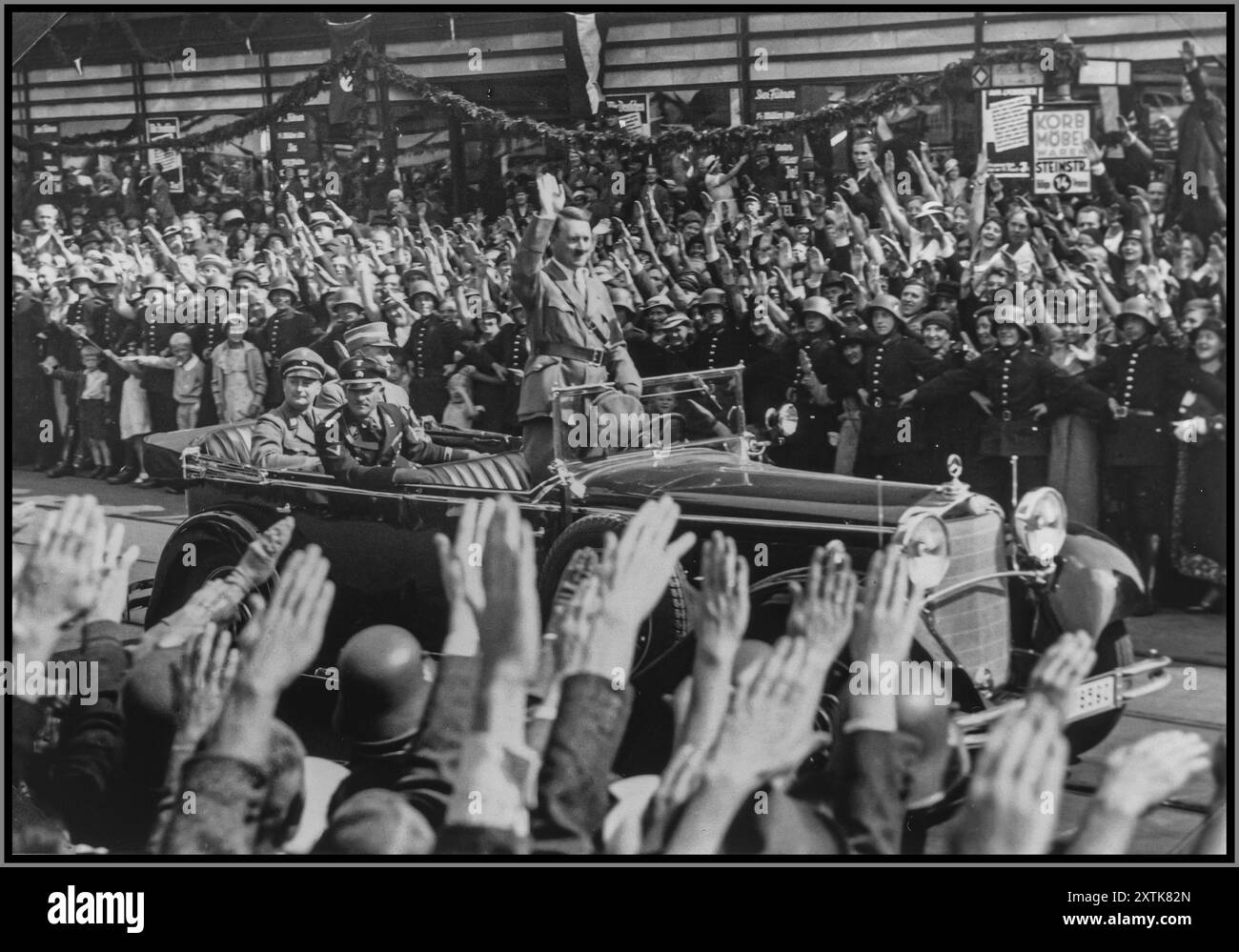 ADOLF HITLER DER 1930er Jahre MIT EKSTATISCHEN MENSCHENMENGEN, DIE SICH WINKEN HEIL HITLER GRÜSST in seinem offenen Mercedes-Auto stehend, grüßt Adolf Hitler eine Menschenmenge, die die Straßen Hamburgs säumt. Im Wagen mit Hitler sind der Hamburger Gauleiter Karl Kauffmann und der SS-Obergruppenführer Joseph „Sepp“ Dietrich abgebildet. 17. August 1934 Hamburg, [Hansestadt] Deutschland Stockfoto