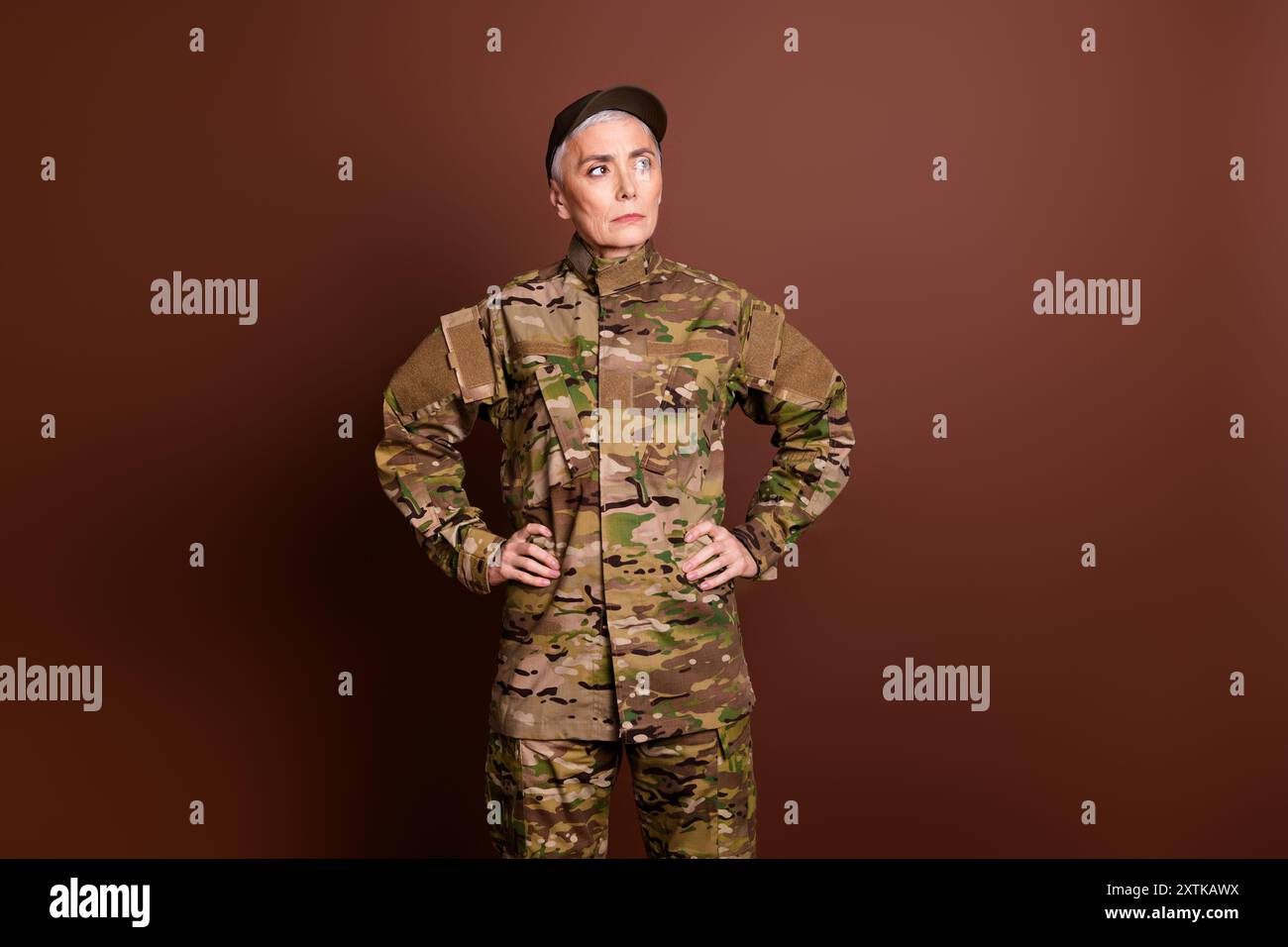 Foto einer selbstbewussten starken pensionierten Frau tragen Tarnschutz kämpfende Freiheit leerer Raum isolierter brauner Hintergrund Stockfoto