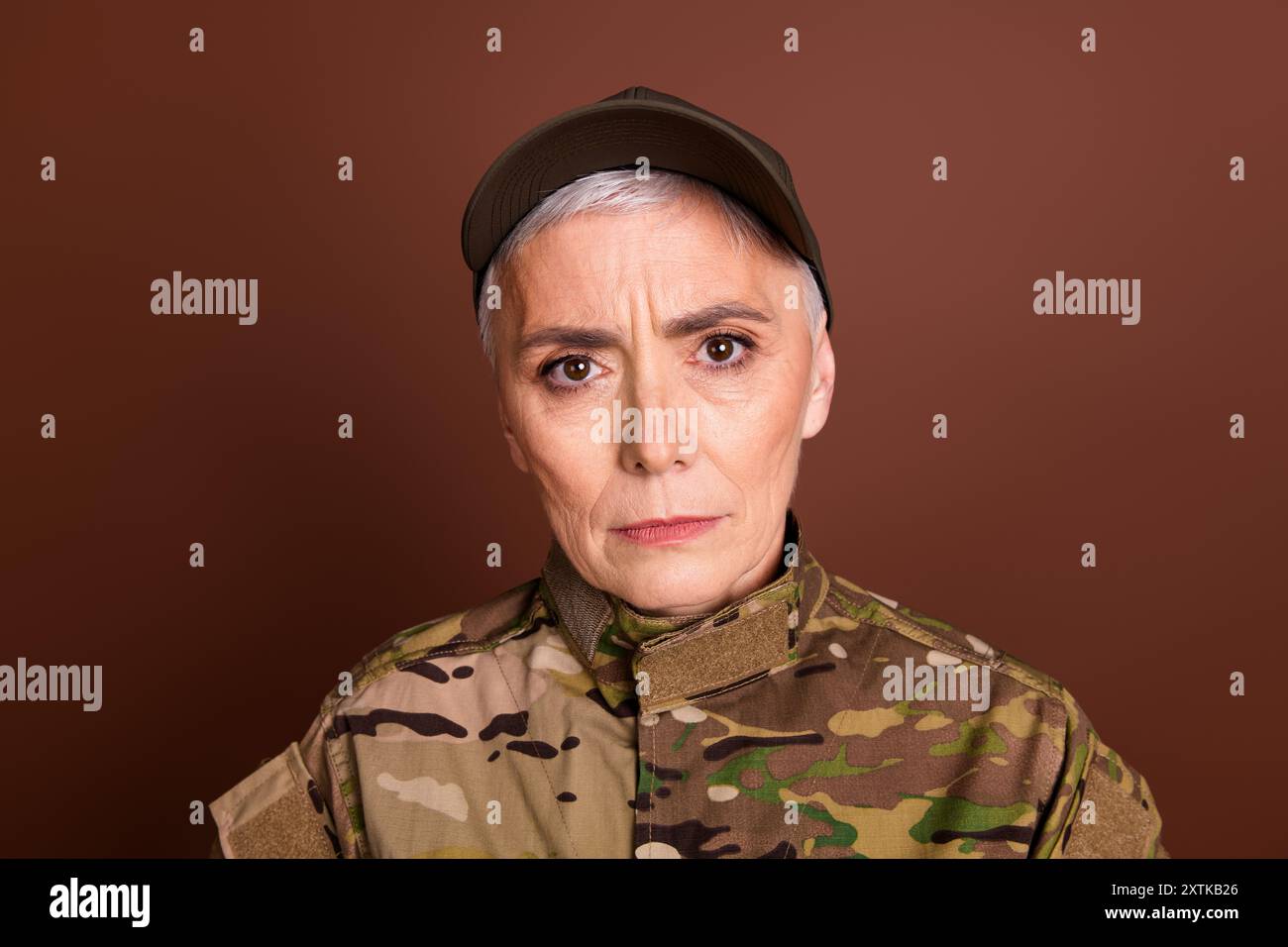 Foto von Militär-selbstbewusster Senior-Frau tragen Tarnung leeren Raum isolierten braunen Hintergrund Stockfoto