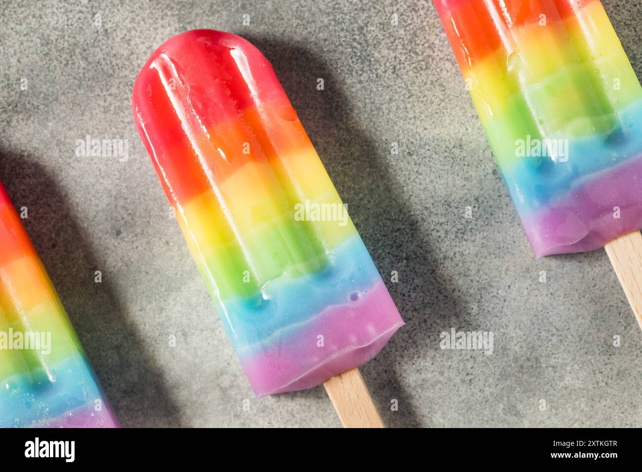 Süße Sommer-Regenbogenkaffel mit verschiedenen Fruchtaromen, auf grauem Tischhintergrund Stockfoto