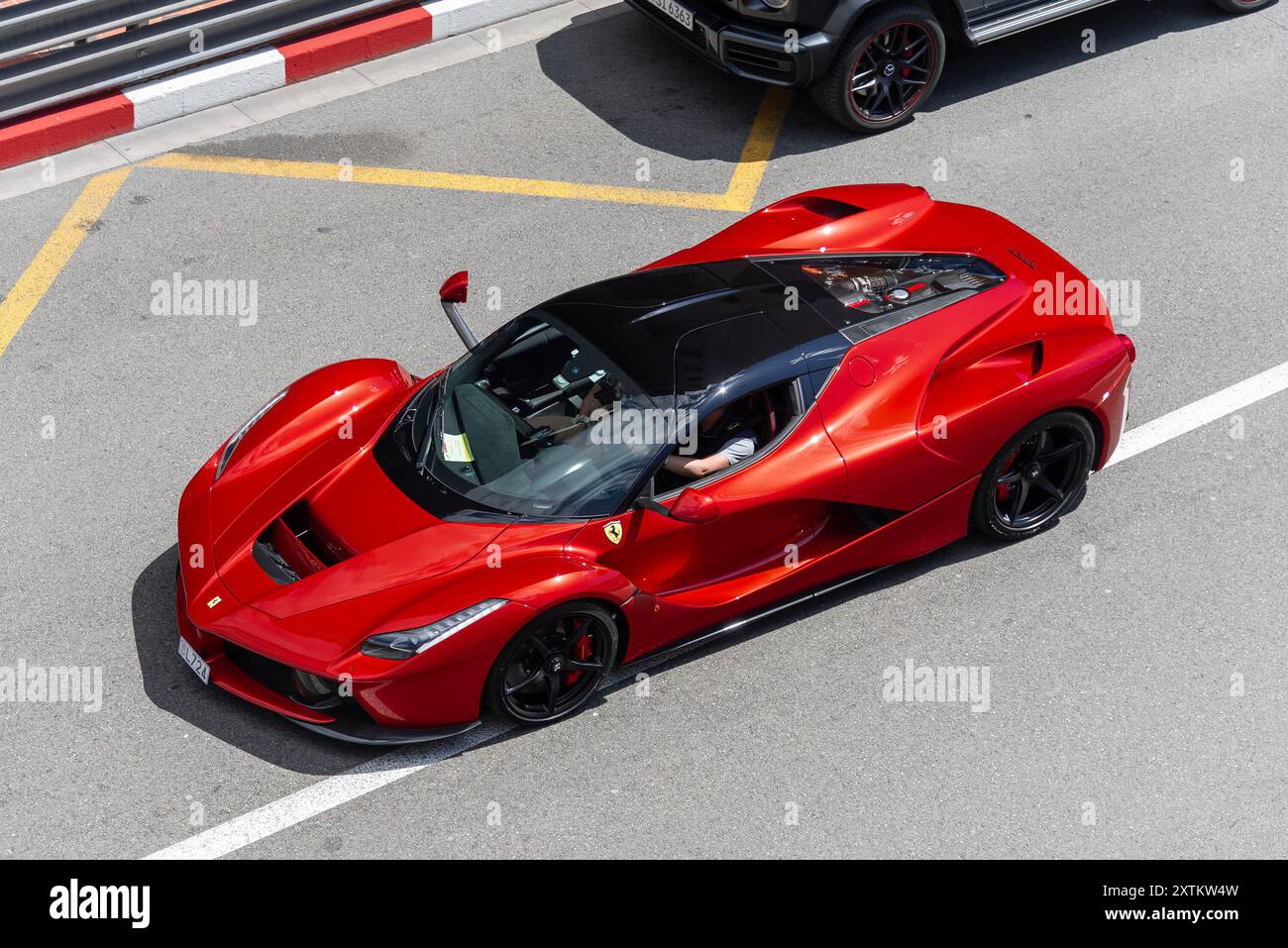 Monte Carlo, Monaco - Blick auf einen roten Ferrari LaFerrari, der auf der Straße in der Fairmont Haarnadelkurve fährt. Stockfoto