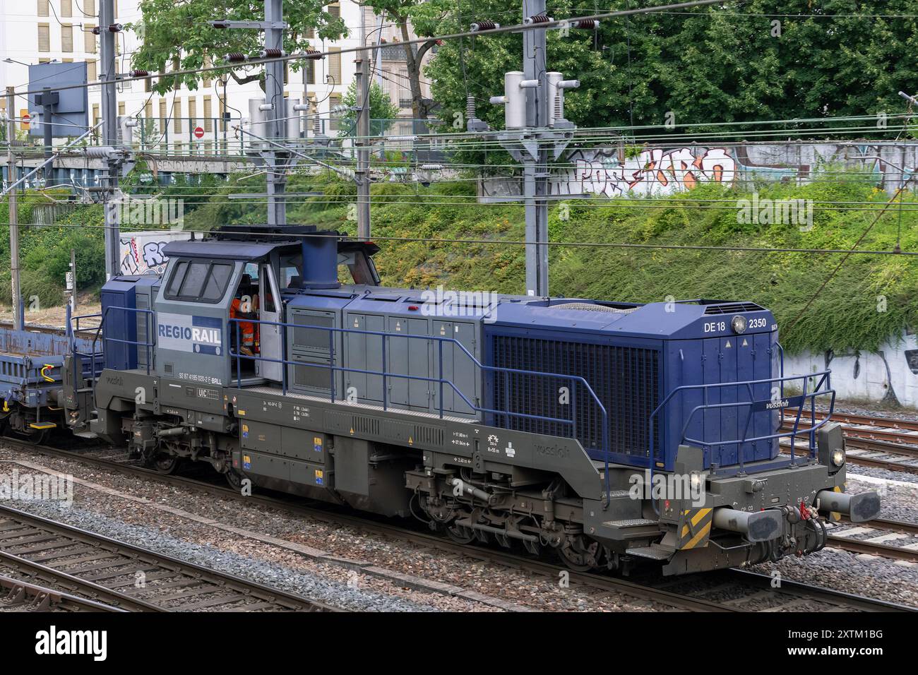 Nancy, Frankreich - Blick auf eine grau-blaue dieselelektrische Lokomotive Vossloh DE 18, die den Bahnhof Nancy überquert. Stockfoto