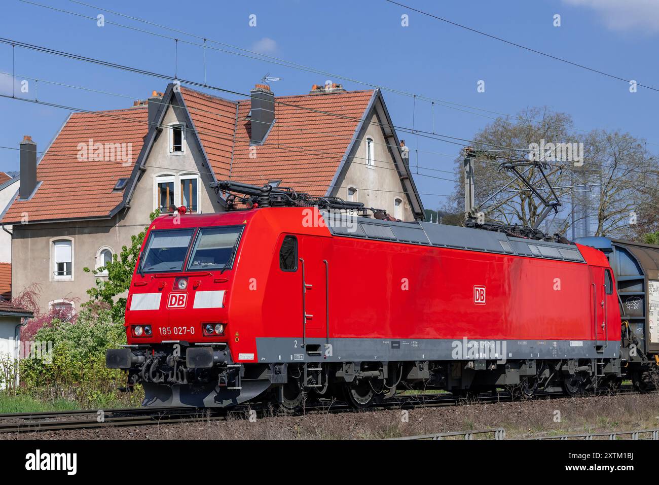 Nancy, Frankreich - Blick auf eine rote Elektrolokomotive Bombardier TRAXX auf den Schienen, die den Bahnhof Nancy unter blauem Himmel überqueren. Stockfoto