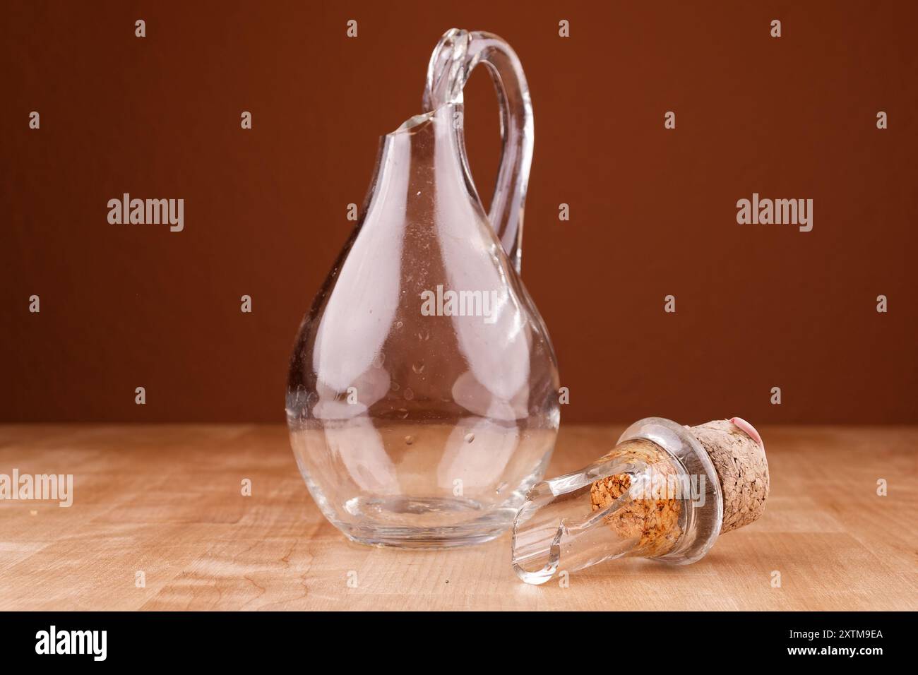Kaputte Glasflasche mit Kork auf Holztisch, Nahaufnahme, kaputte Struktur Stockfoto