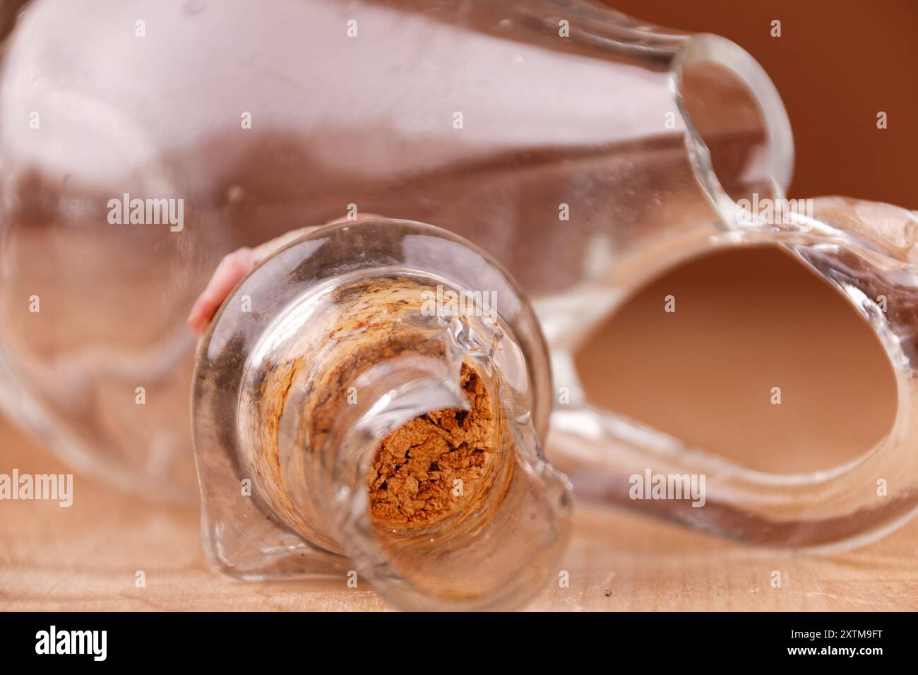 Kaputte Glasflasche mit Kork auf Holztisch, Nahaufnahme, kaputte Struktur Stockfoto