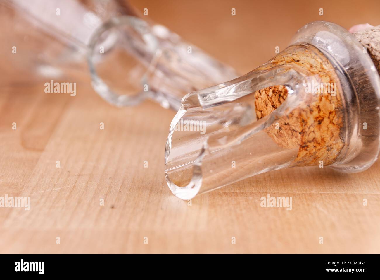 Kaputte Glasflasche mit Kork auf Holztisch, Nahaufnahme, kaputte Struktur Stockfoto