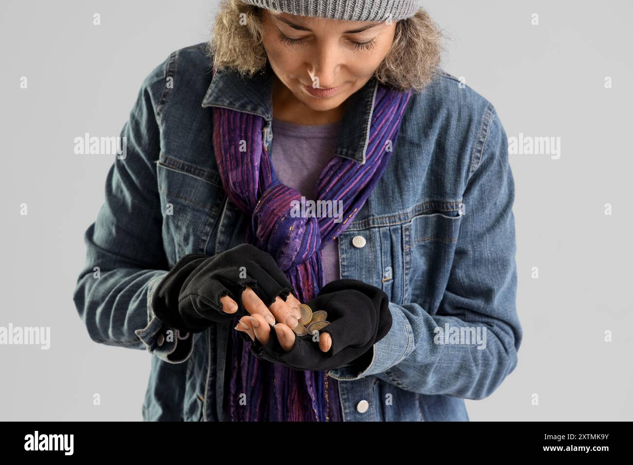 Reife obdachlose Frau zählt Münzen auf hellem Hintergrund, Nahaufnahme Stockfoto