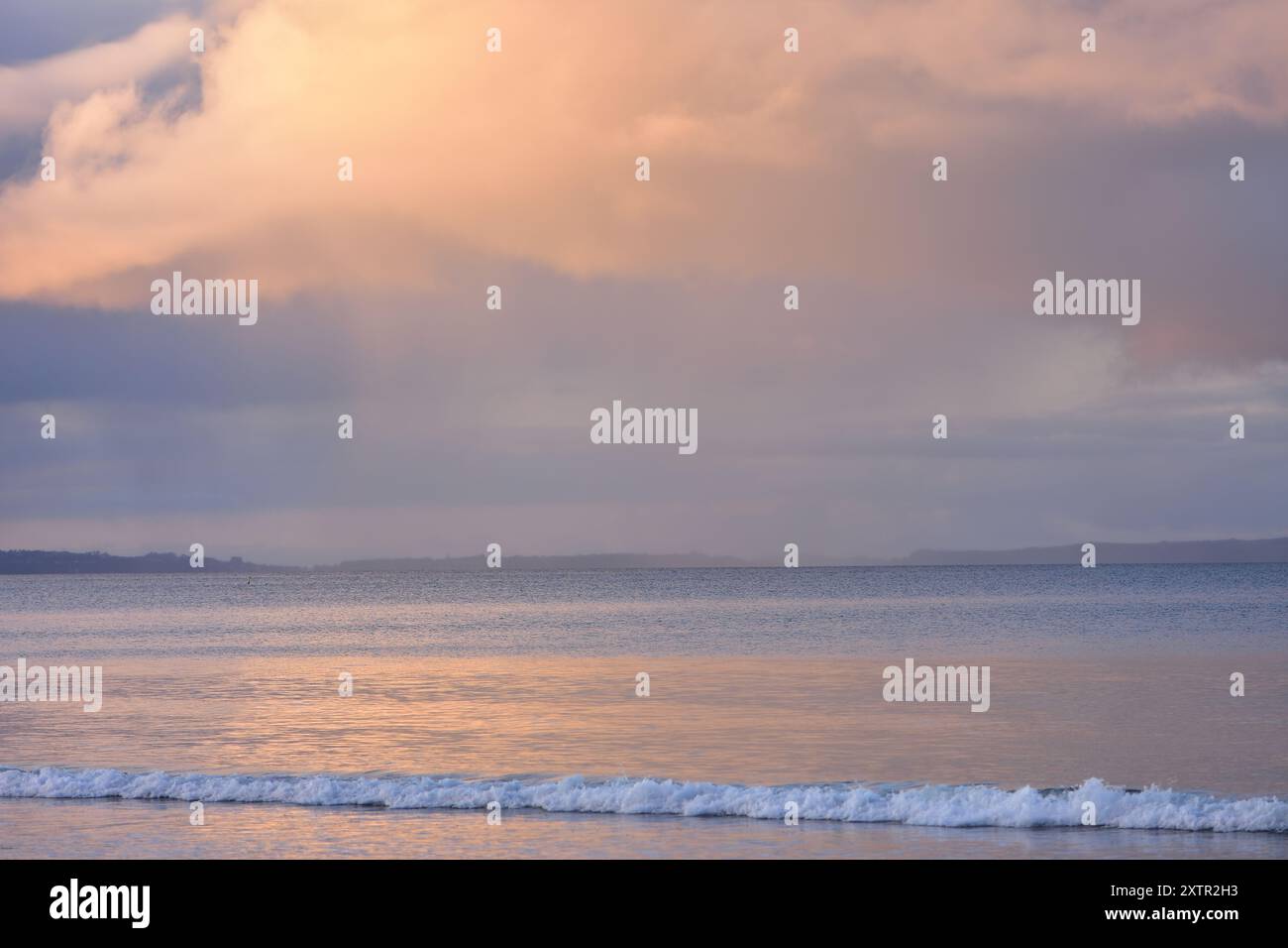 Regen strömt von Sturmwolken in den inneren Hauraki Golf vom ruhigen Takapuna Strand aus. Lage: Takapuna Auckland Neuseeland Stockfoto