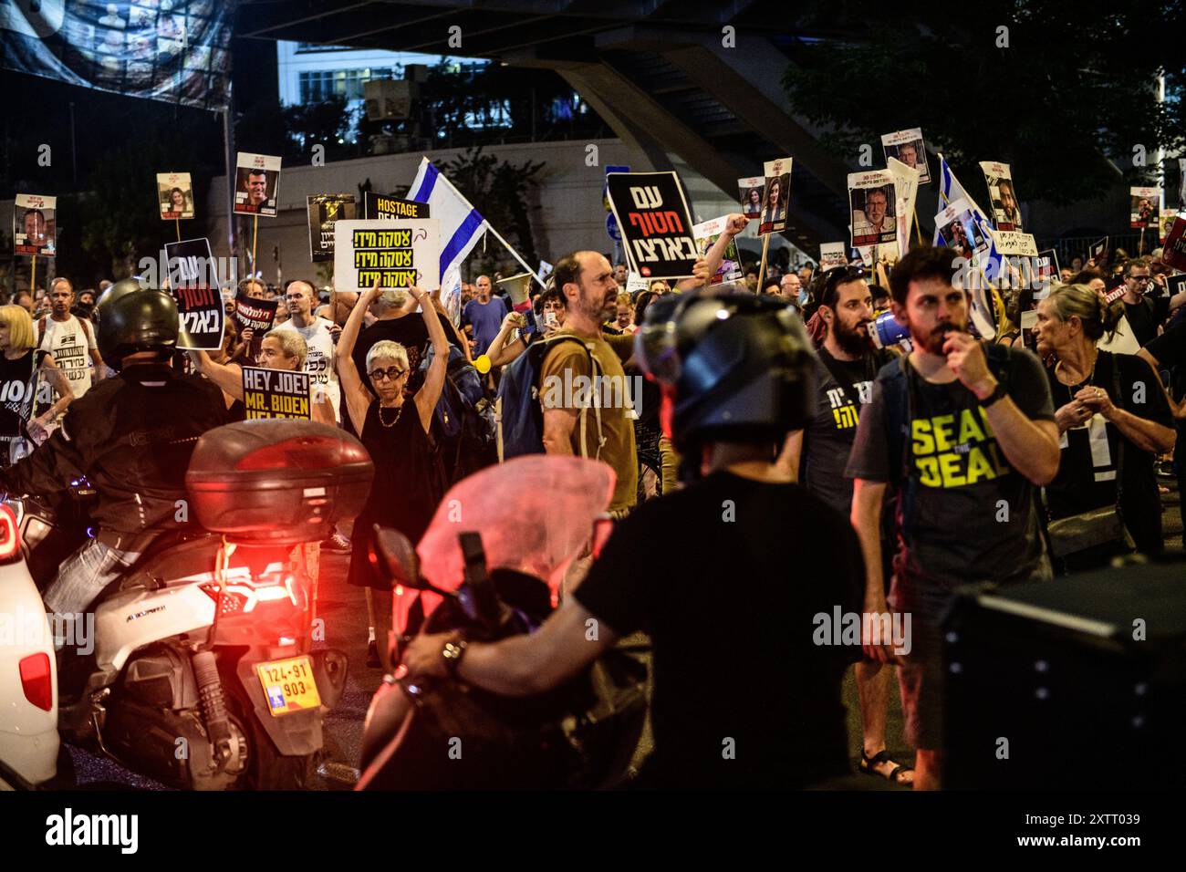 Israel. August 2024. Demonstranten blockieren die Straße, während sie Schilder mit den Fotos der israelischen Geiseln hochhalten, auf denen steht: „Seal the Deal“. Die Israelis demonstrierten mit den Familien der Geiseln gegen Premierminister Benjamin Netanjahu und forderten ein sofortiges Geiselabkommen und einen Waffenstillstand - während in Katar Verhandlungen über den Waffenstillstand im Gazastreifen stattfinden. Tel Aviv, Israel. August 2024. (Matan Golan/SIPA USA). Quelle: SIPA USA/Alamy Live News Stockfoto