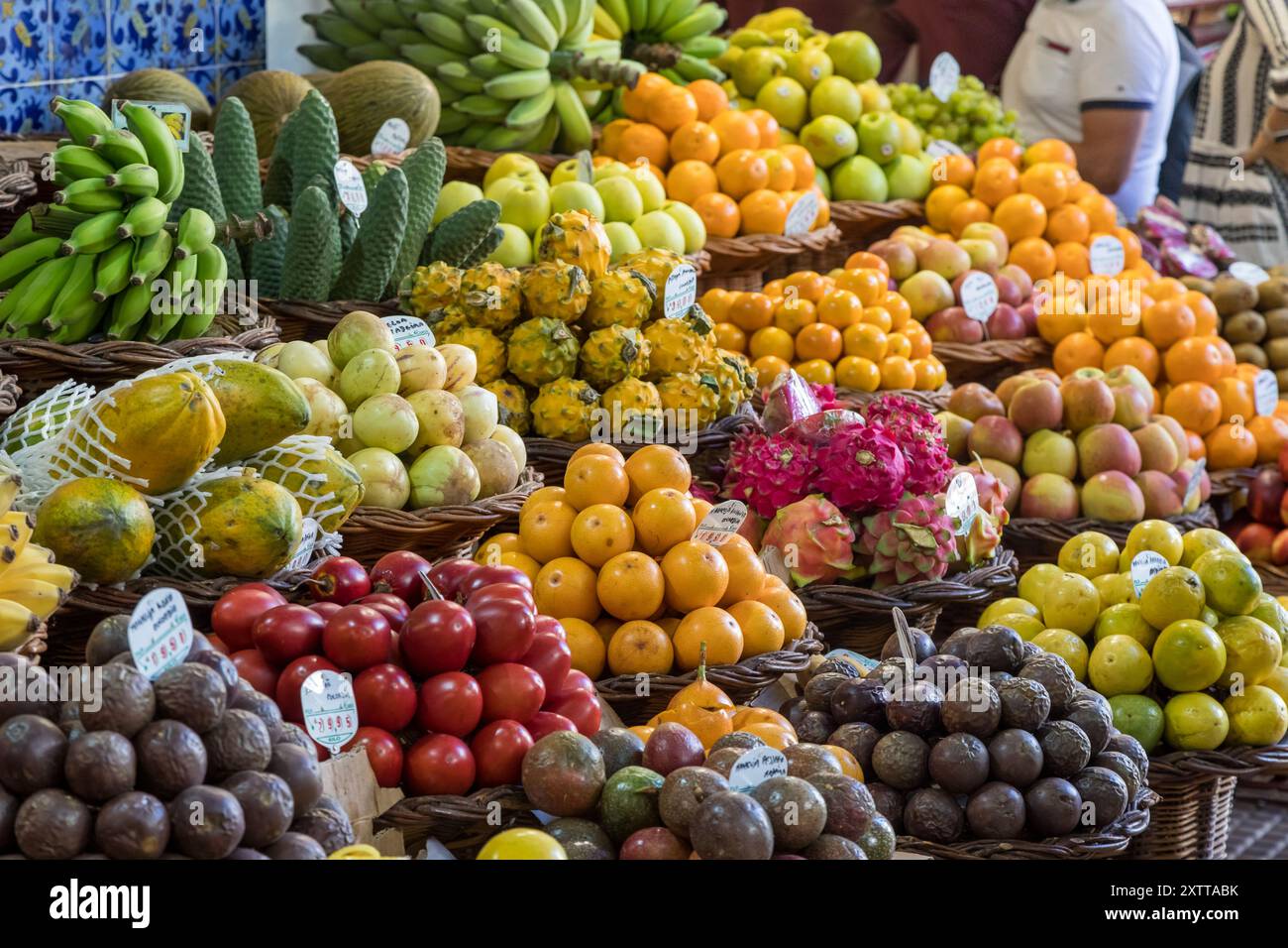 Farbenfrohe frische Früchte, die ordentlich in Häufchen platziert werden und am 6. August 2024 auf dem Markt Mercado dos Lavradores im Herzen von Funchal, Madeira, verkauft werden. Stockfoto