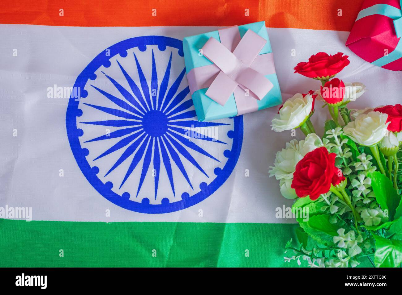 Indische Flagge mit Blume und Geschenkbox auf indischem Flaggenhintergrund für Unabhängigkeitstag. Draufsicht Stockfoto