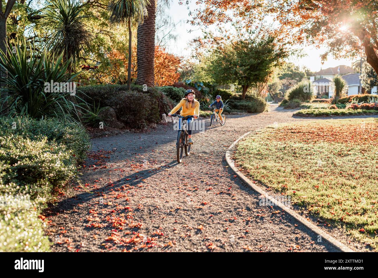 Glückliche Kinder, die im Park in Neuseeland Fahrrad fahren Stockfoto