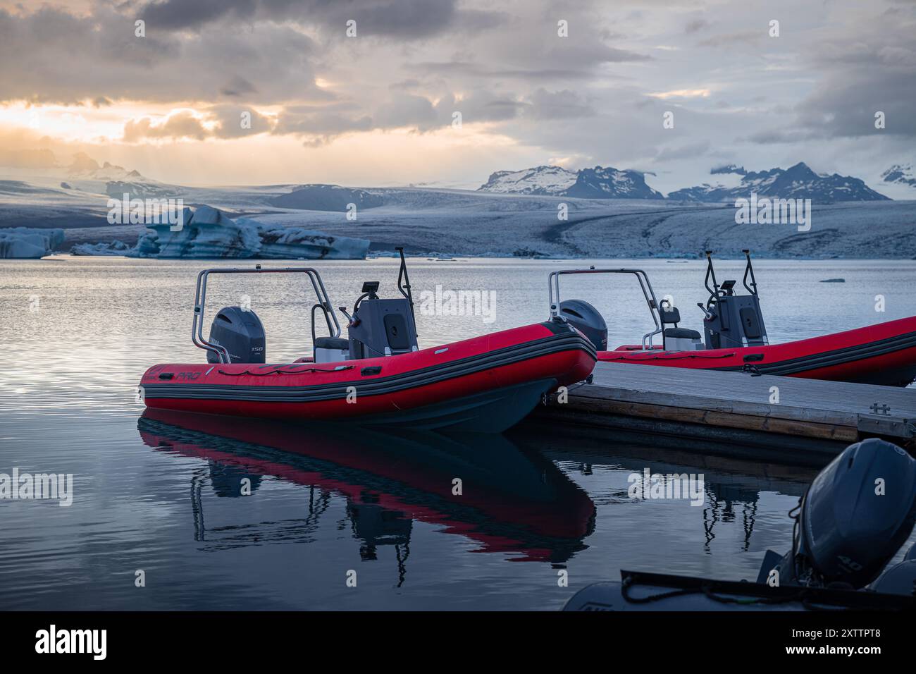 Rote Motorboote liegen in der Nähe des Piers in der Gletscherlagune Stockfoto