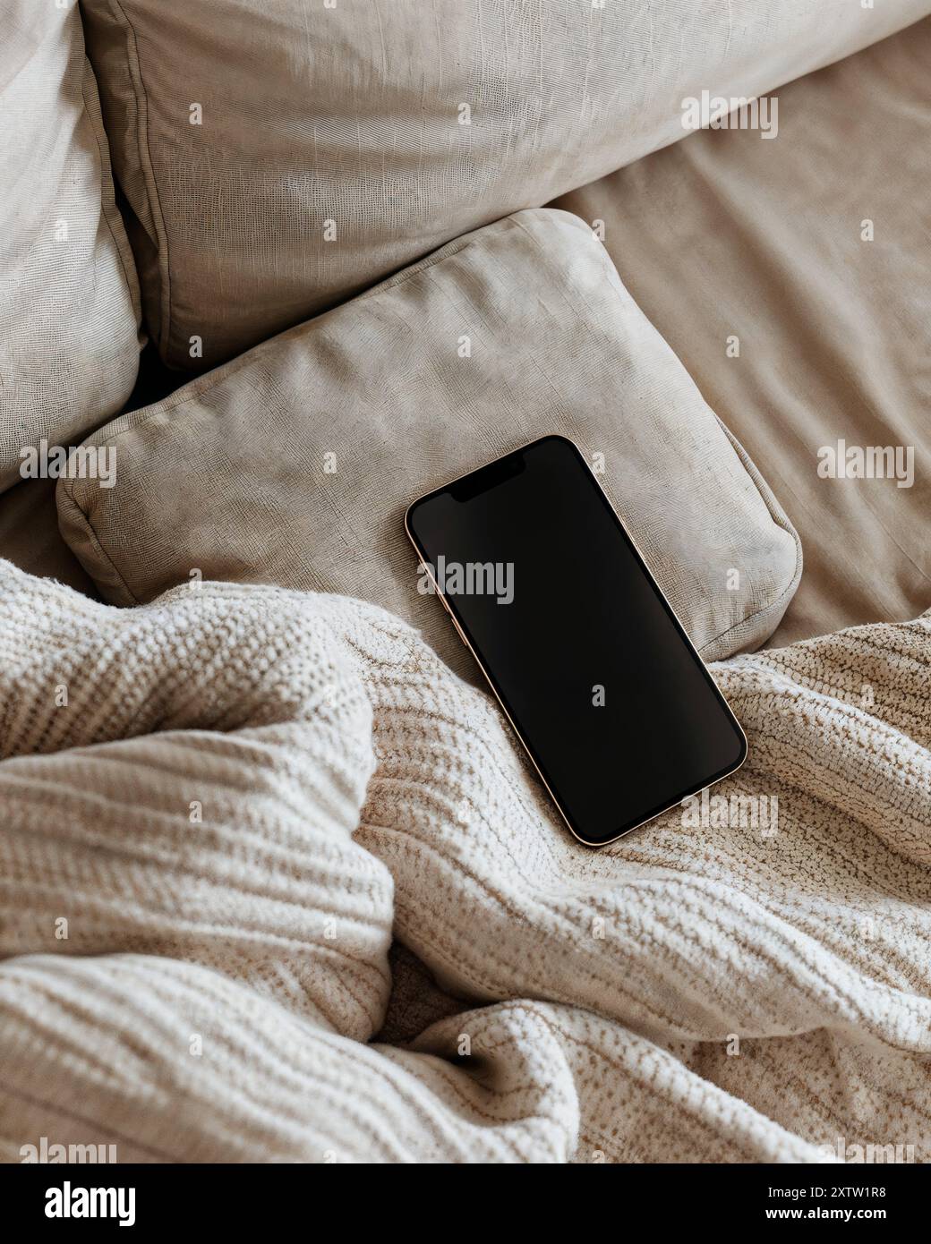 Foto-Modell des Geräts auf Sofa, Textil, Modell, moderner und ästhetischer Stil, Smartphone-Modell beige Ästhetik Stockfoto