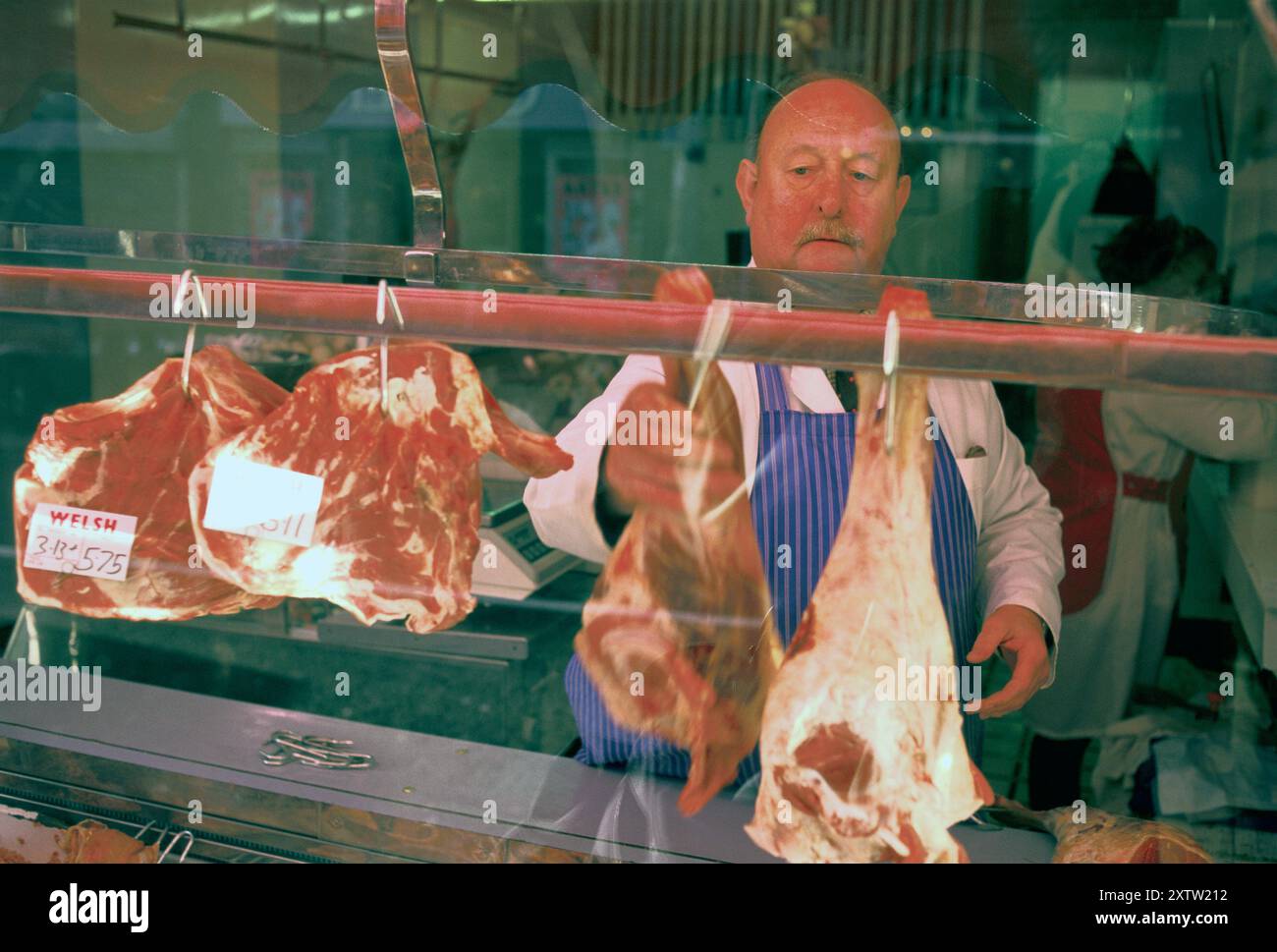Der walisische Metzger Tom Price in seinem traditionellen lokalen Metzgerladen in der Oxford Street. Er trug Arbeitskleidung und war sein ganzes Leben lang Metzger. Mountain Ash, Glamorgan, Südwales, 1998 1990er Jahre, Großbritannien HOMER SYKES Stockfoto