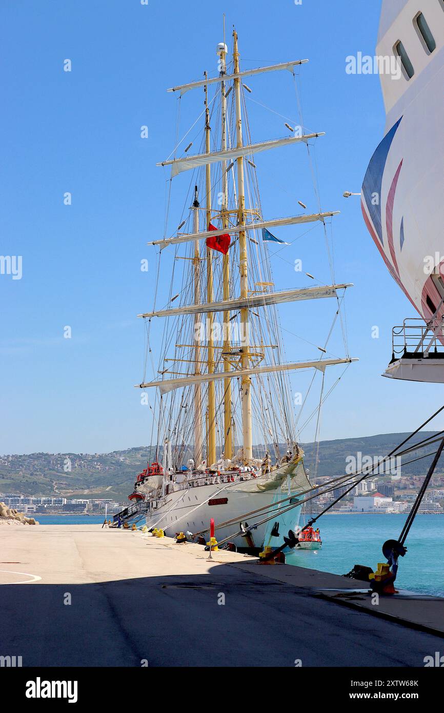 Ein Kontrast zwischen dem traditionellen Segelschiff „Star Flyer“ und dem modernen Kreuzfahrtschiff „Aurora“, das im Hafen von Tanger, Marokko, im April 2024 ankerte. Stockfoto