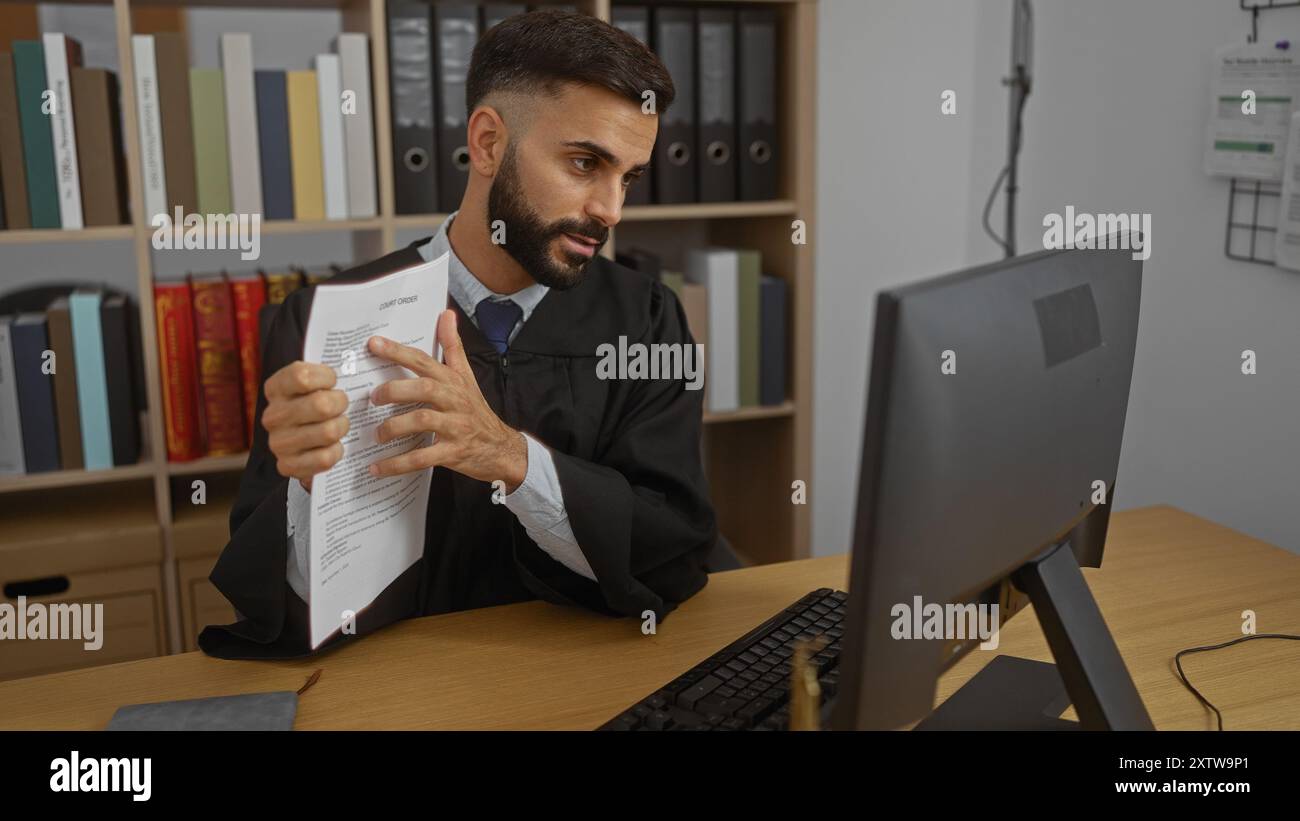 Junger Mann mit Bart im Büro, der Dokumente während der Videokonferenz zeigt, umgeben von Büchern und Ordnern, was auf eine legale Umgebung hinweist. Stockfoto