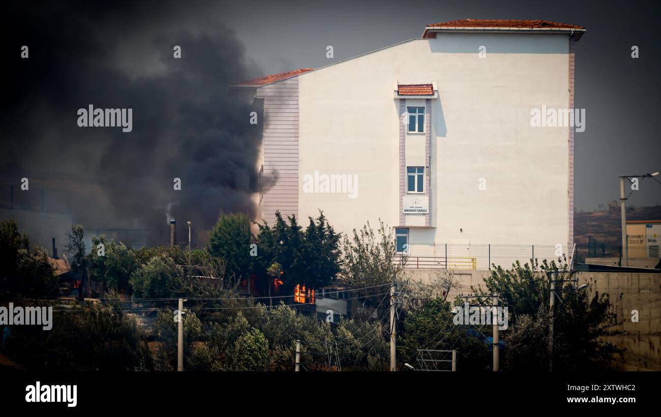 Izmir, Türkei. August 2024. Die Bemühungen um das Löschen eines Waldbrandes, der gestern Abend in einem Wald im Gebiet Yamanlar des Bezirks ​​the Karsıyaka in Izmir ausgebrochen ist, werden auf dem Land- und Luftweg fortgesetzt. Einige Viertel, in denen die Flammen aufgrund des starken Windes in Wohngebiete gelangten, wurden evakuiert. Es wurde beobachtet, dass das Feuer, das sich über ein weites Gebiet ausbreitete, einige Häuser, eine Schule und ein Industriegebiet verbrannte. Quelle: İdil Toffolo/Alamy Live News Stockfoto
