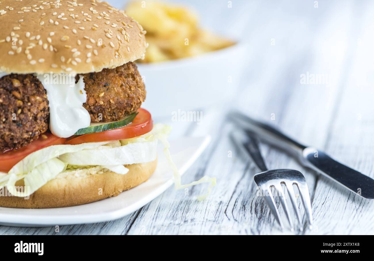 Frisch zubereiteter Falafel Burger (Nahaufnahme, selektiver Fokus) auf hölzernem Hintergrund Stockfoto