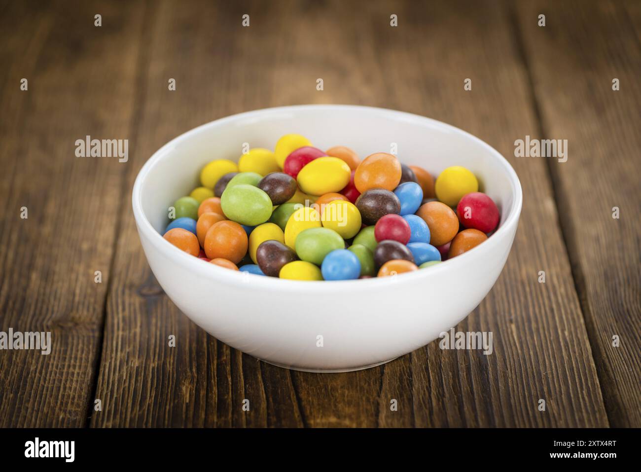 Frischen Cocolate beschichtet Erdnüsse auf einem vintage Hintergrund (Nahaufnahme) Stockfoto