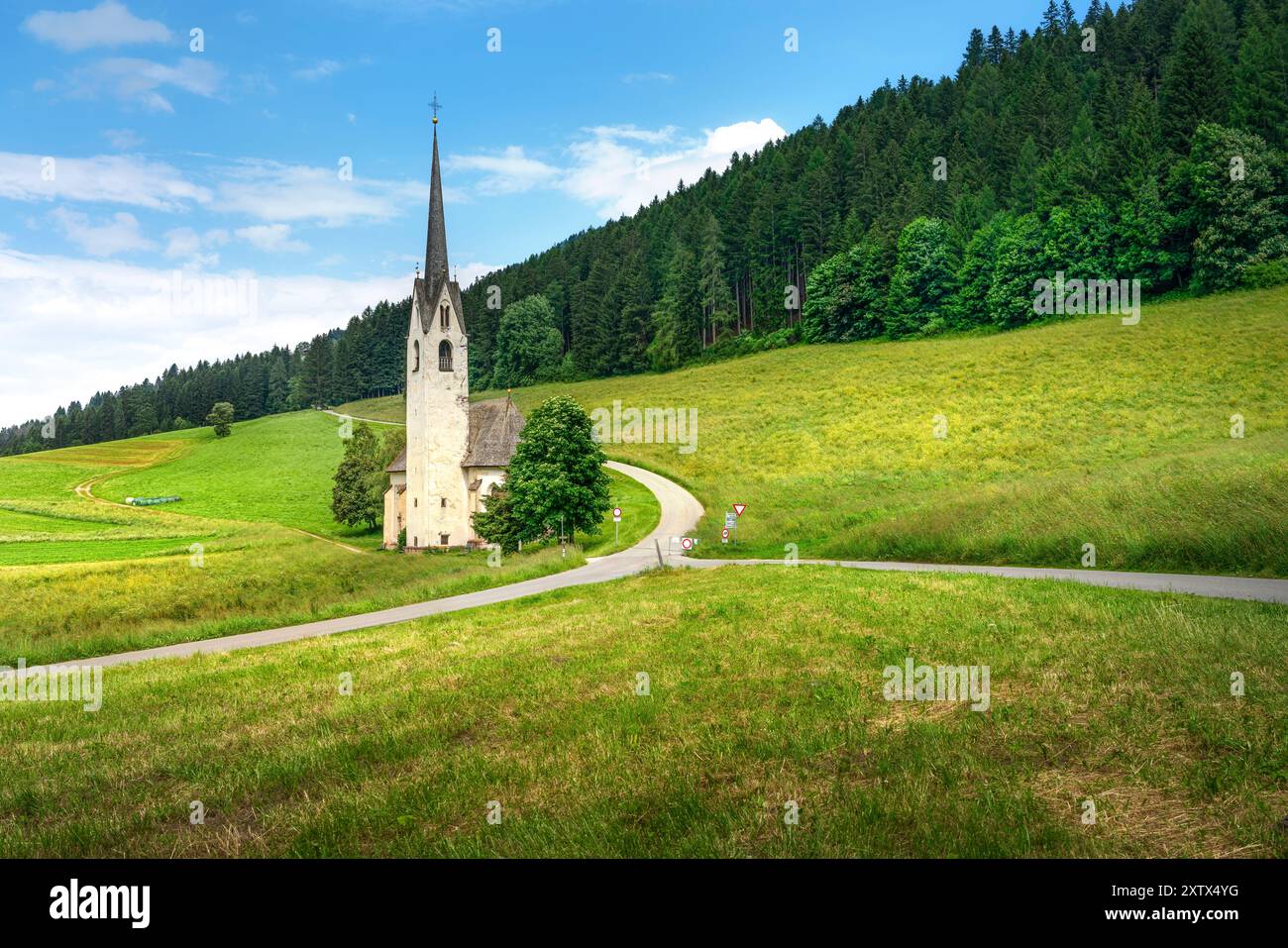 Atemberaubende Aufnahme der Kirche Santa Maddalena di Villabassa, eingebettet in die malerischen Dolomiten, mit ihrer ruhigen Schönheit und majestätischen Kulisse. Stockfoto