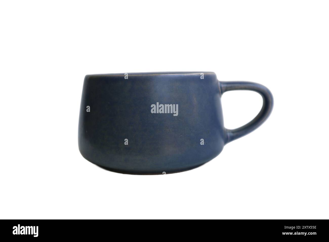 Eine blaue Keramikkkaffeetasse sitzt auf weißem Hintergrund. Der Becher ist groß und hat ein einfaches Design Stockfoto