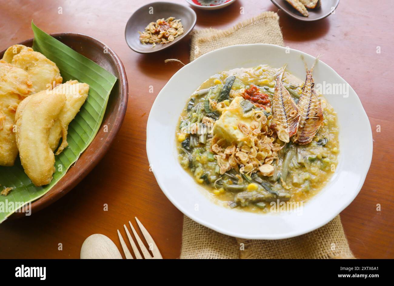Manado Brei oder Tinutuan Brei ist traditioneller Brei. Manadonesischer Reisbrei, gemischt mit Kürbis, Mais, Gemüse. Serviert mit gesalzenem Tofu Stockfoto