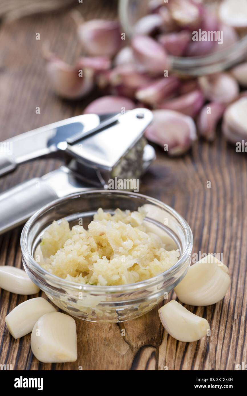 Zerdrückten Knoblauch (Nahaufnahme) auf rustikalen hölzernen Hintergrund Stockfoto