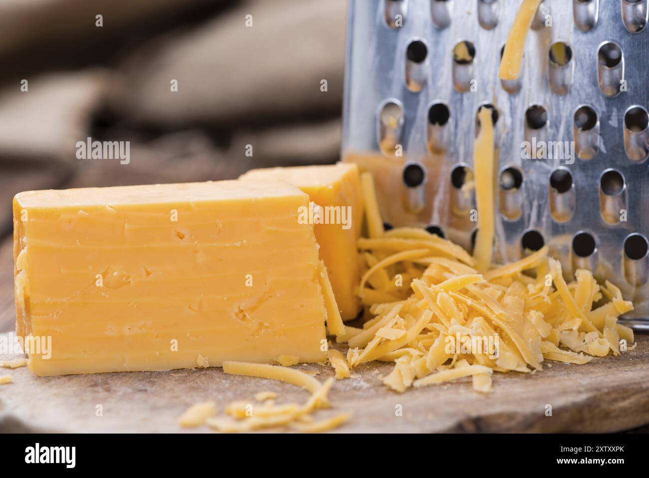 Teil des geriebenen Cheddar-Käse auf rustikalen hölzernen Hintergrund Stockfoto