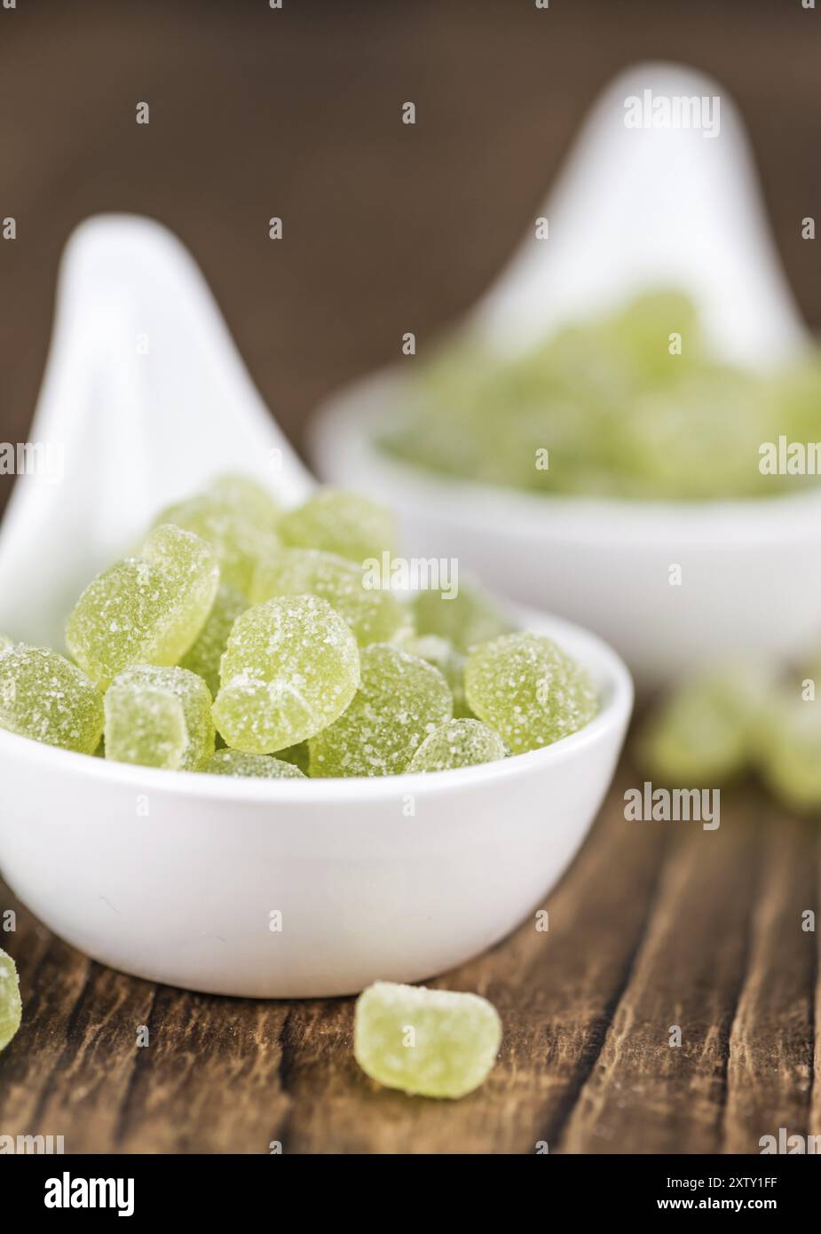 Holztisch mit sauren Gummibärchen Bonbons (Apfel Geschmack) als detaillierte Nahaufnahme Stockfoto