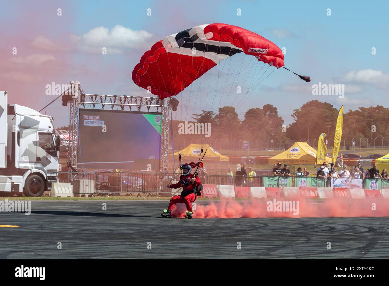 British Motor Show 2024, in Farnborough, Hampshire, England, Vereinigtes Königreich vom 15. bis 18. August 2024. Tag 2 der jährlichen Veranstaltung im Farnborough International Exhibition Centre. Die Red Devils British Army Parachute Display Team Himmel tauchte in die Arena ein. Stockfoto