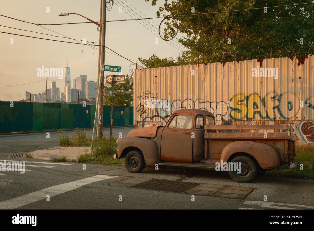 Alter Truck mit Graffiti und Blick auf die Skyline von Lower Manhattan, in Red Hook, Brooklyn, New York Stockfoto