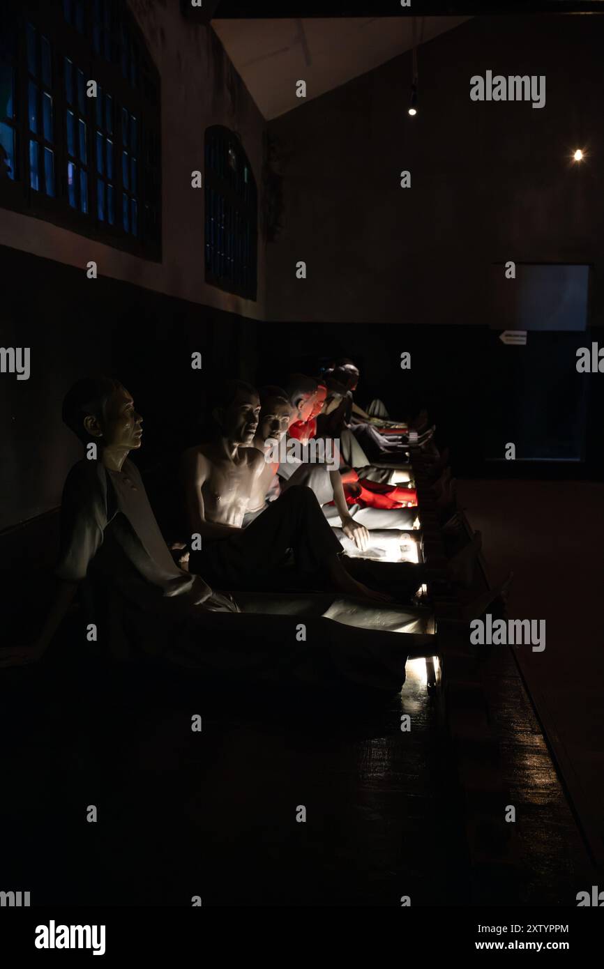 Hoa Lo Gefängnismuseum mit Statuen, die Gefangene im dunklen Kerker „Cachot“ darstellen. Stockfoto