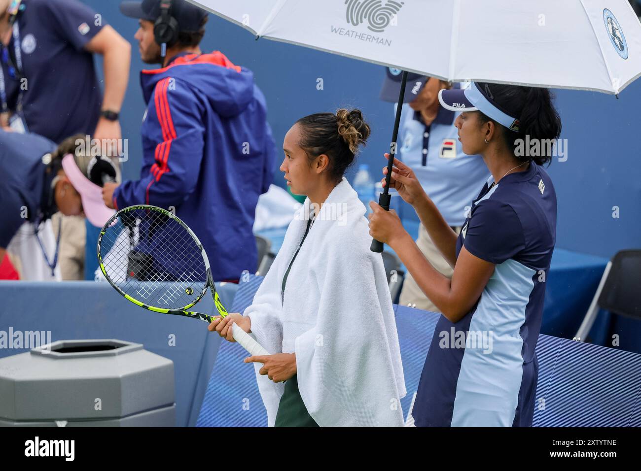 Mason, Ohio, USA. August 2024. Leylah Fernandez (CAN) wartet während der Sechzehntelrunde am Freitag bei den Cincinnati Open im Lindner Family Tennis Center, Mason, Oh, auf eine kurze Regenzeit unter einem Handtuch und einem Regenschirm. (Kreditbild: © Scott Stuart/ZUMA Press Wire) NUR REDAKTIONELLE VERWENDUNG! Nicht für kommerzielle ZWECKE! Quelle: ZUMA Press, Inc./Alamy Live News Stockfoto