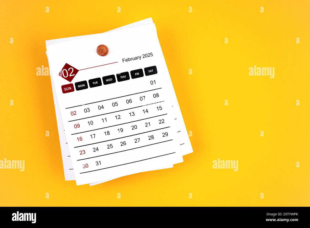 Kalenderseite Februar 2025 mit hölzerner Stecknadel auf gelbem Hintergrund, Position mit Kopierraum. Stockfoto