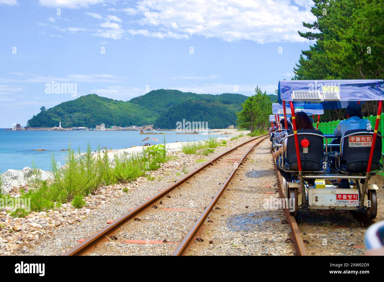 Samcheok, Südkorea - 29. Juli 2024: Ein Rail Bike fährt entlang der Samcheok Marine Rail Bike Route und bietet einen malerischen Blick auf den Hafen von Chogok in Th Stockfoto