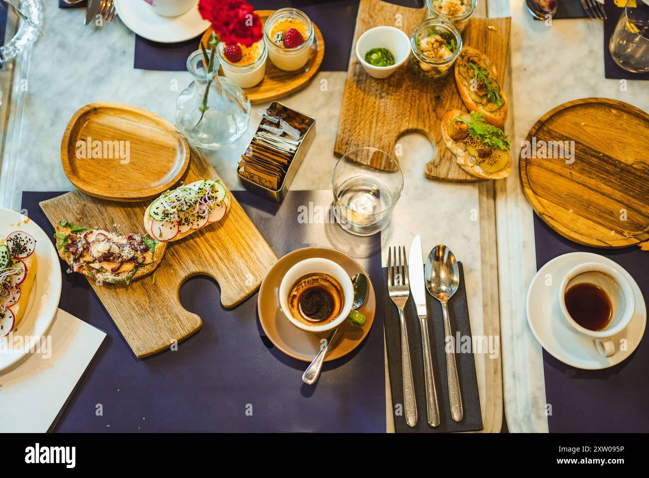 Tisch im Frühstücksrestaurant. Aufnahme des Tisches von oben. Warmes Brot und Kaffee. Getränke und Essen. Stockfoto