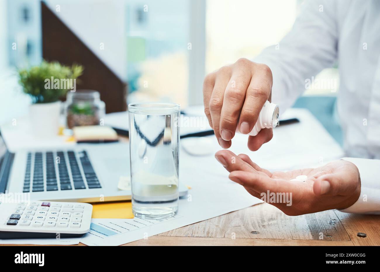 Geschäftsmann, Laptop und Medikamente mit Glas Wasser zur Verschreibung oder Tagesdosis im Büro. Nahaufnahme der Hände oder des Mitarbeiters mit Mineralflüssigkeit Stockfoto