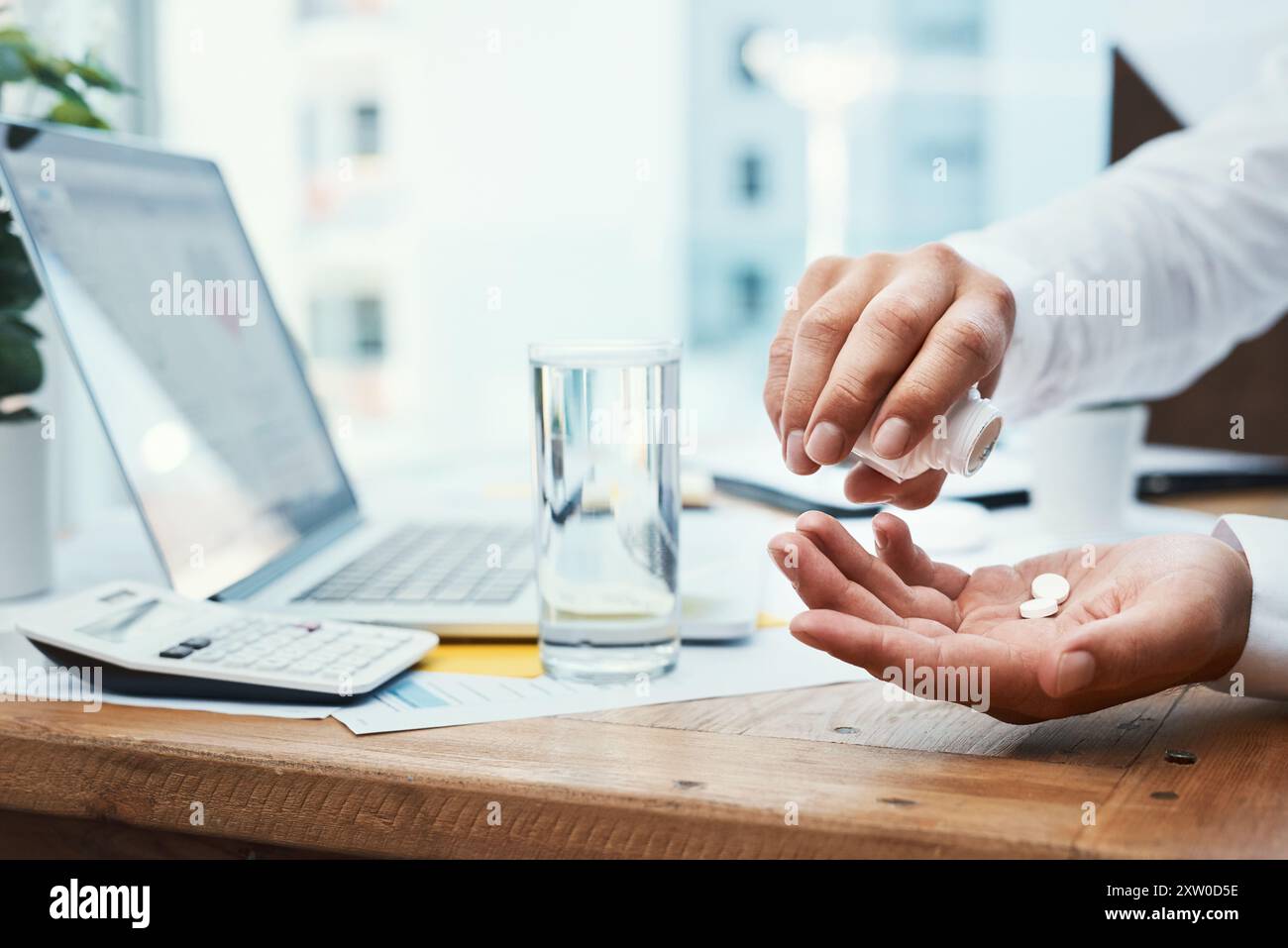 Geschäftsmann, Laptop und Pillen mit Wasser zur Verschreibung oder Tagesdosis im Büro. Nahaufnahme der Hände des Mitarbeiters, der Mineralflüssigkeit oder der Medikamente für Stockfoto