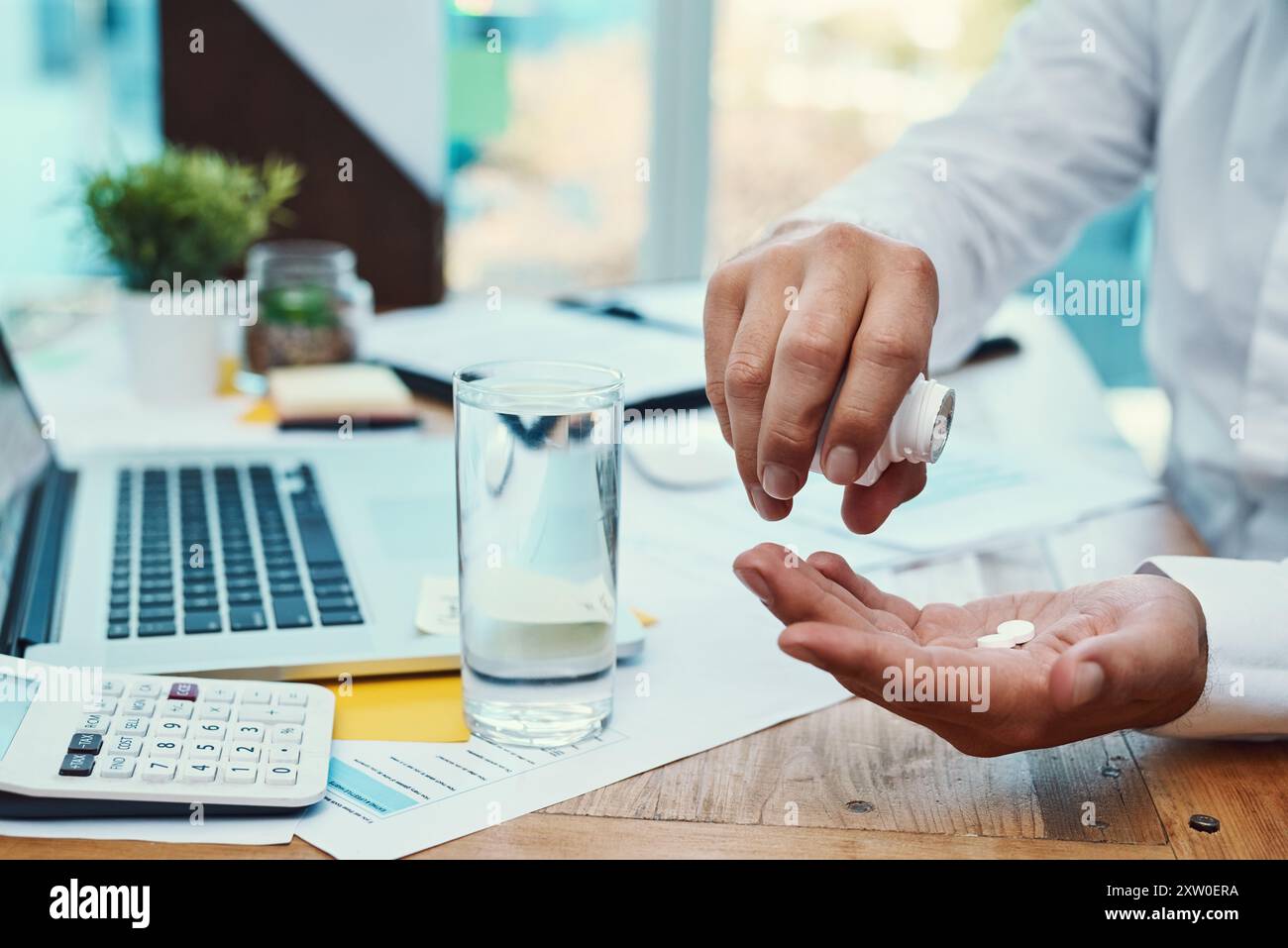 Geschäftsmann, Laptop und Medikamente mit Wasser zur Verschreibung oder Tagesdosis im Büro. Nahaufnahme der Hände des Mitarbeiters, Mineralflüssigkeit oder Pillen für Stockfoto