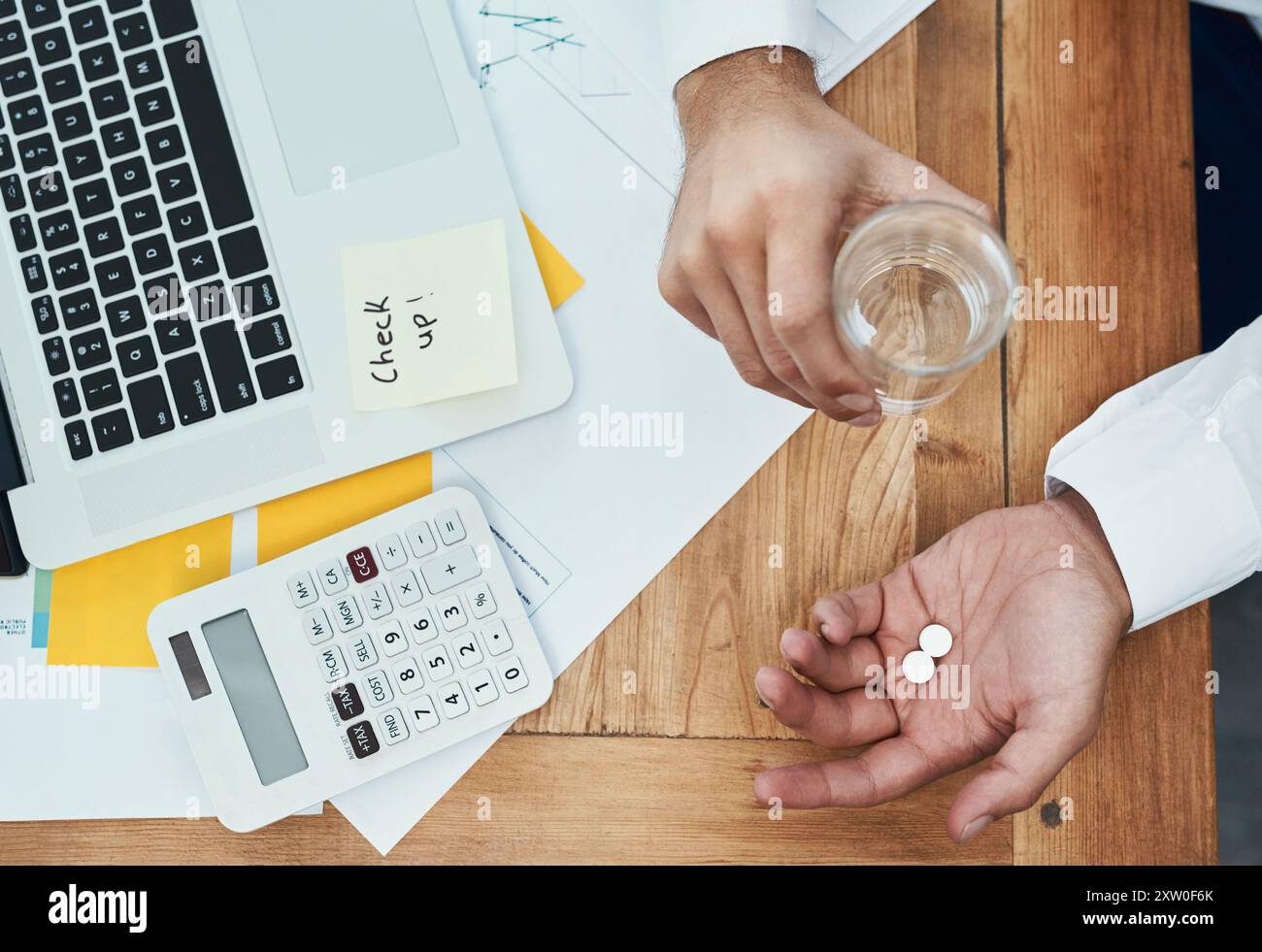 Geschäftsmann, Laptop und Pillen mit Wasser oben für Medikamente, Rezepte oder tägliche Dosierung im Büro. Draufsicht des Mitarbeiters mit Mineralflüssigkeit und Stockfoto