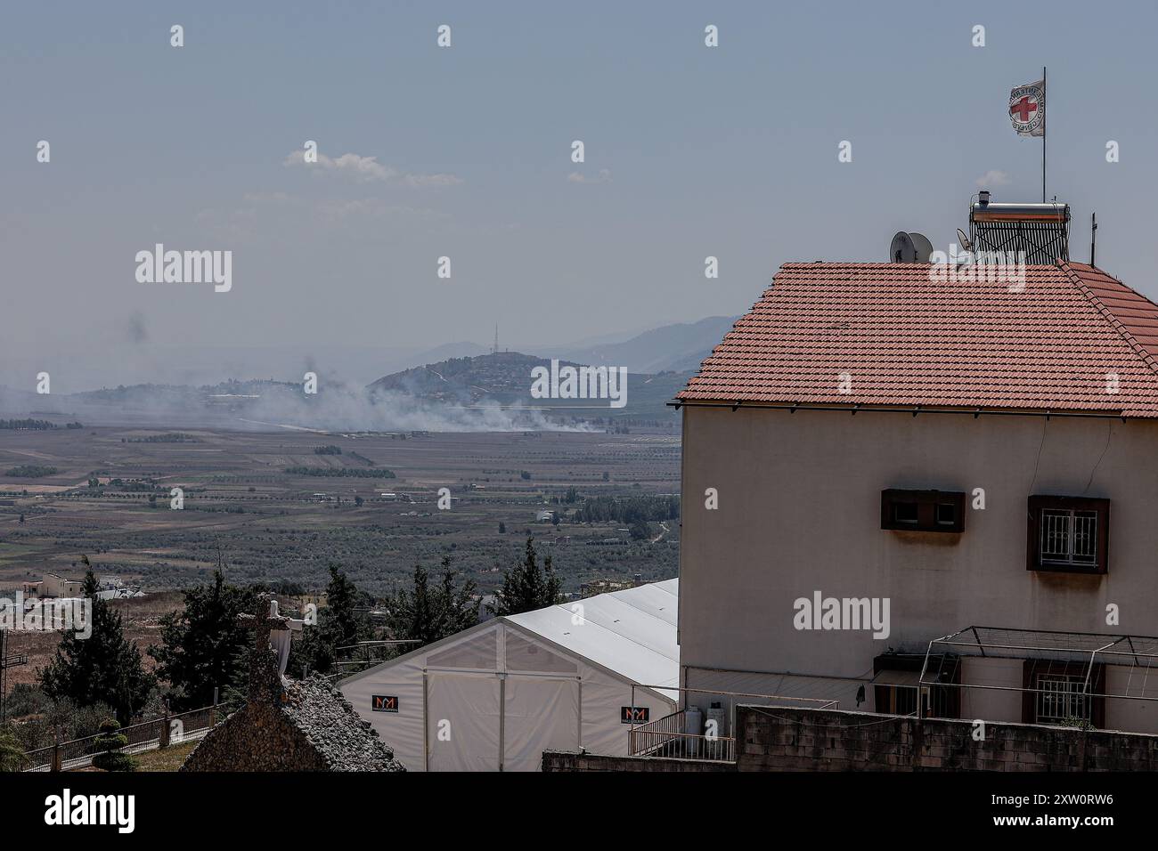 Marjayoun, Libanon. August 2024. Ein Blick auf ein Feld und ein Gebäude mit rotem Kreuz in der Nähe der südlibanesischen Stadt KHIAM im südlichen Libanon nahe der Grenze zu Israel nach israelischen Bombardierungen, während anhaltender Auseinandersetzungen zwischen der Hisbollah der IDF. (Foto: Vasily Krestyaninov/SOPA Image/SIPA USA) Credit: SIPA USA/Alamy Live News Stockfoto