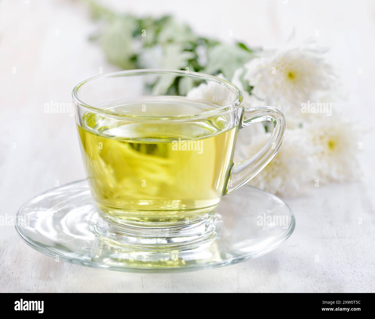 Tasse Kräutertee und Blumen Stockfoto