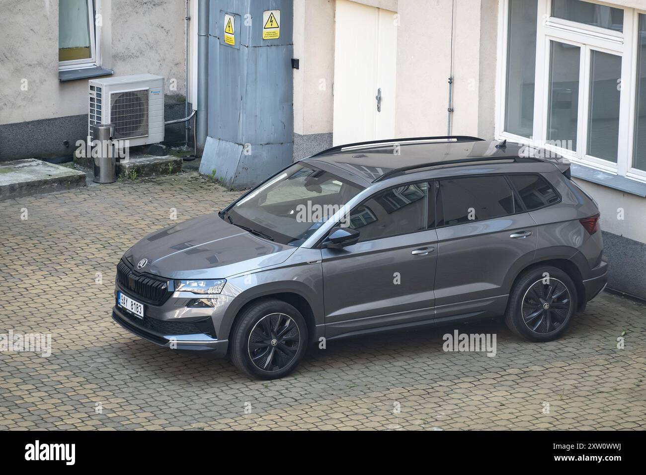 OSTRAVA, TSCHECHISCHE REPUBLIK - 13. SEPTEMBER 2023: Grauer Skoda Karoq SUV parkt in der Nähe eines Industriegebäudes Stockfoto