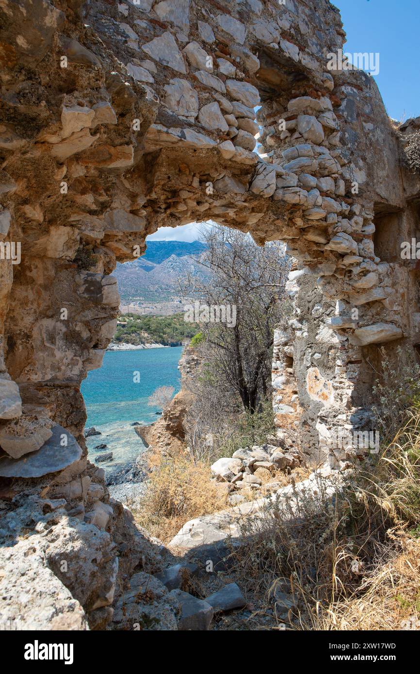 Die Maueröffnung aus Stein bietet einen Blick auf das türkisfarbene Wasser und die Berge Stockfoto