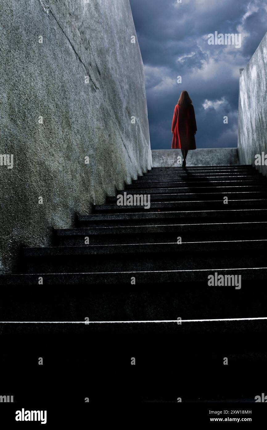 Frau im roten Mantel, die auf einer Treppe hochgeht Stockfoto