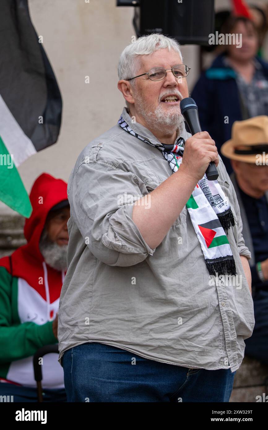 Manchester, Großbritannien. August 2024. Alan Davies von der Word-Zeitung. Am 46. Wochenende des palästinensischen Gazastreifens, seit dem 7. Oktober 2023. Zu den Rednern zählten Christopher Williamson, stellvertretender Vorsitzender der Workers Party of Britain und ehemaliger Labour-Abgeordneter und Schattenminister für Gemeinschaften und lokale Regierung, sowie Alan Davies von der Zeitung Word. Der Protest, der im Zentrum von Manchester stattfand, wurde von einem freien venezolanischen Protest am Cenotaph auf dem Manchesters St Peter's Square begrüßt. . Quelle: GaryRobertsphotography/Alamy Live News Stockfoto