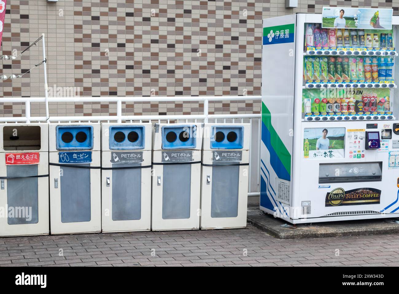 Ein Verkaufsautomat in Japan mit Mülltonnen an der Seite Stockfoto