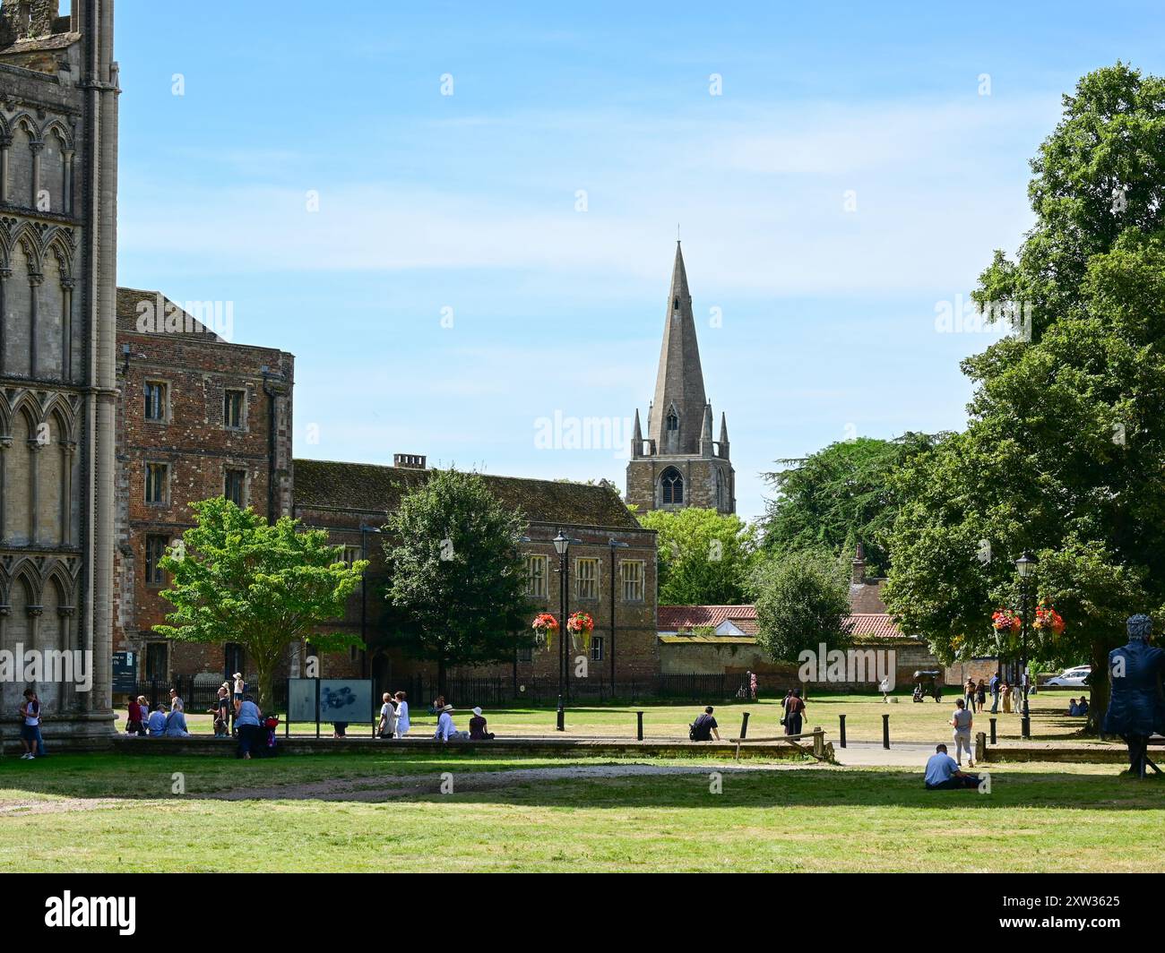 Überqueren Sie Green neben der Kathedrale mit Palace Green, dem Bischofspalast und dem Turm der St. Mary's Church dahinter, Ely, Cambridgeshire, England, Großbritannien Stockfoto